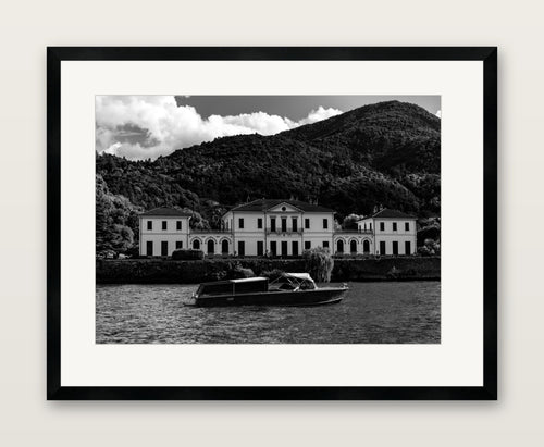 end game, black and white photograph of a lakeside villa and wooden motorboat, A2 print in a black wood gallery frame with an even museum mat